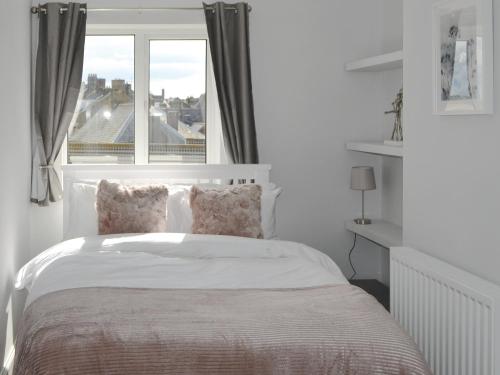 een slaapkamer met een bed en een groot raam bij Bertys Beach View in Woodhorn