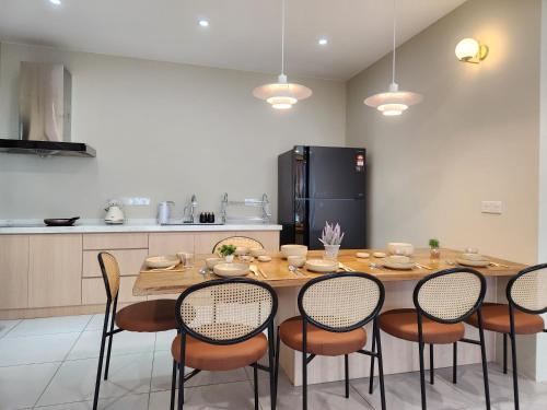 a kitchen with a table with chairs and a refrigerator at Kuching Prime Location Emporium - Nordict Retrett - 10 Pax in Kuching