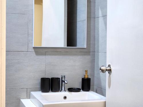 a bathroom with a white sink and a mirror at Kuching Prime Location Emporium - Nordict Retrett - 10 Pax in Kuching