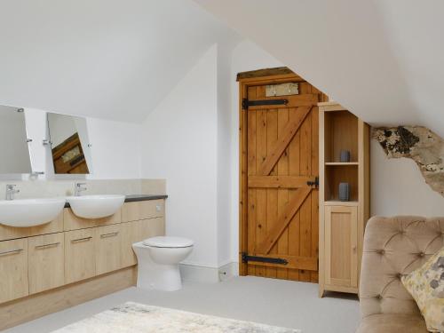 a bathroom with a toilet and a sink and a door at Clawdd Gwyn in Llanrwst