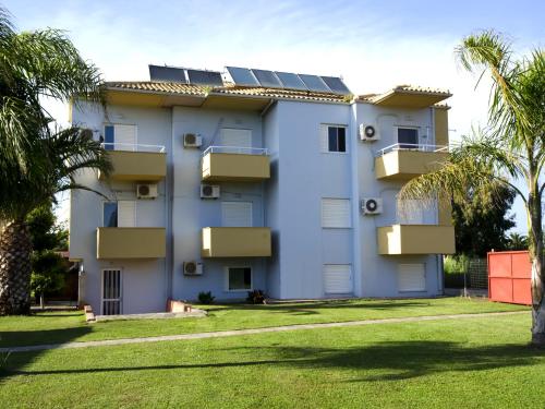 a white building with solar panels on it at Voula Apartments in Mitikas