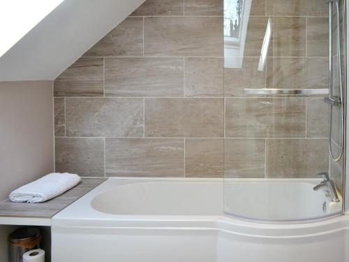 a bathroom with a shower and a bath tub at Crofters Cottage in Rothbury