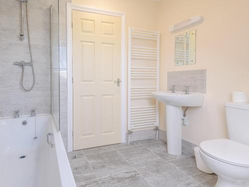 uma casa de banho com uma porta branca, um lavatório e um WC. em Dawson Park 1 - Uk12660 em Mablethorpe