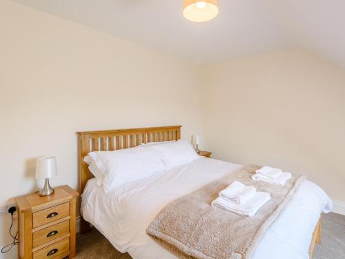 梅布爾索普的住宿－Dawson Park 1 - Uk12660，一间卧室配有白色床单和床头柜。