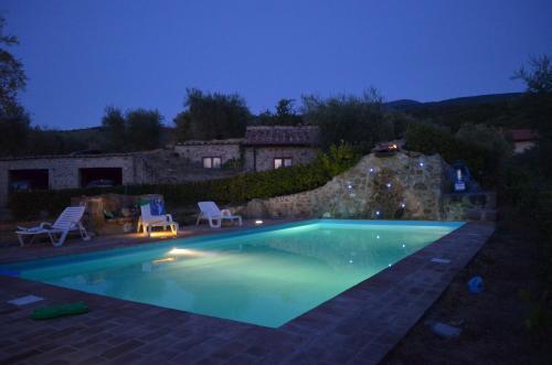 ein Schwimmbad in einem Garten in der Nacht in der Unterkunft Casetta del Pozzo in Seggiano