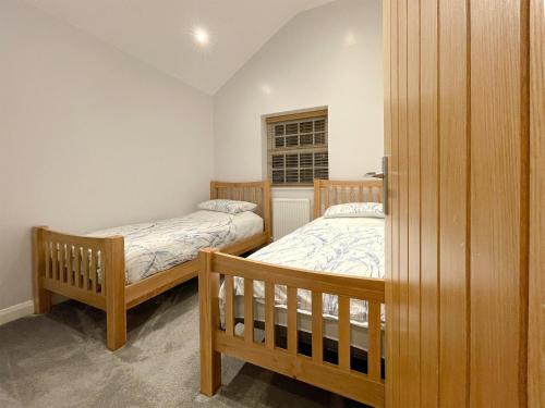 een slaapkamer met 2 bedden en een raam bij Pointer Cottage in Preesall