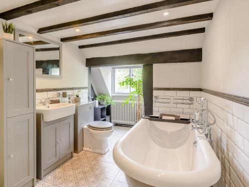 a bathroom with a tub and a toilet and a sink at Yew Tree Farm in Charing
