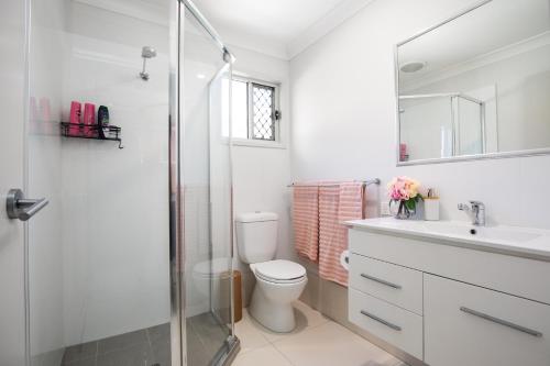 a bathroom with a shower and a toilet and a sink at Modern & Beautifully Presented! Close to Transport in Brisbane