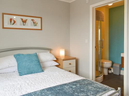 Un dormitorio con una cama con una almohada azul. en Archers Retreat en Greenhill
