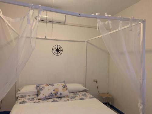una camera da letto con letto e tende bianche di casa in riva al lago Diletta Spiti a Castelletto sopra Ticino
