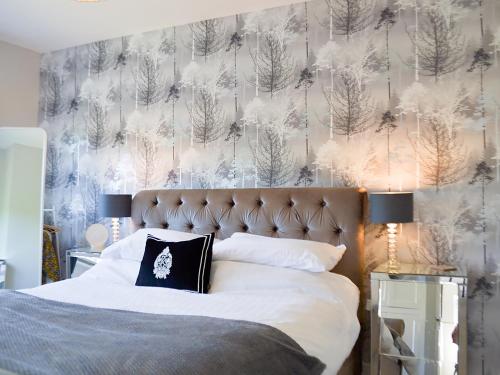 a bedroom with a bed with a winter wallpaper at Silcrest in Baslow