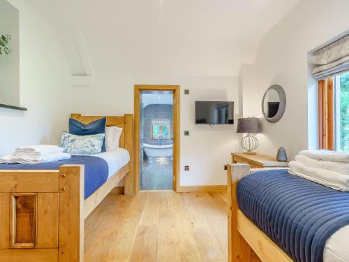 1 dormitorio con 2 camas y baño con bañera en Herdwick View - Uk33668, en Bassenthwaite Lake