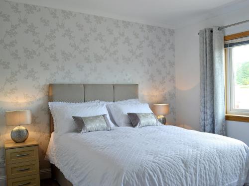 una camera con un letto bianco con due cuscini di Ingleside a Ballantrae