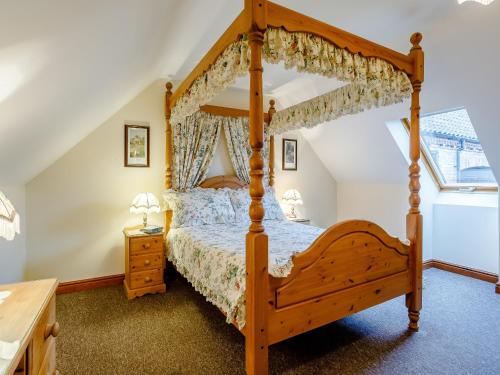 - une chambre mansardée avec un lit à baldaquin dans l'établissement Gable Barn - E3865, à Runcton Holme