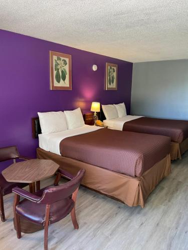 Habitación de hotel con 2 camas y mesa en Budget Host Inn, en Greenup