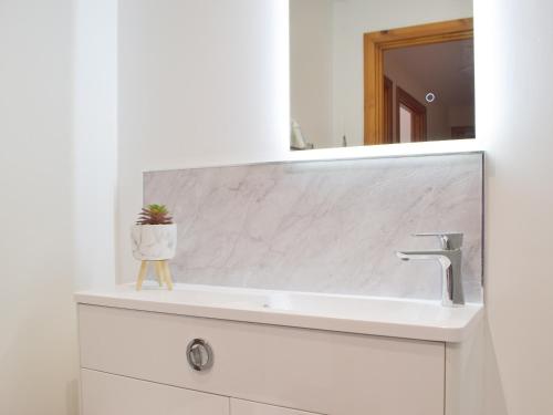 a bathroom with a sink and a mirror at Marina Retreat in Milford Haven