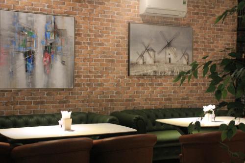 two tables in a restaurant with paintings on the wall at Lanura Apartments and Hotel in Ho Chi Minh City