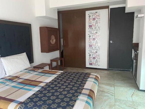 a bedroom with a bed and a door with a poster at Cancún Hotel Boutique & Hostel in Cancún