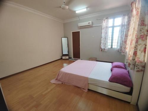 een slaapkamer met een groot bed met paarse kussens bij Nilai Impian Homestay @ Dillenia in Nilai