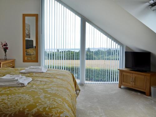 a bedroom with a bed and a large window at The Steading in Dubton