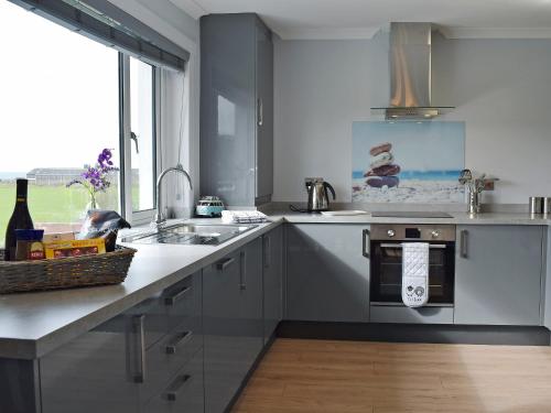 a kitchen with a sink and a stove top oven at Stinchar View in Ballantrae