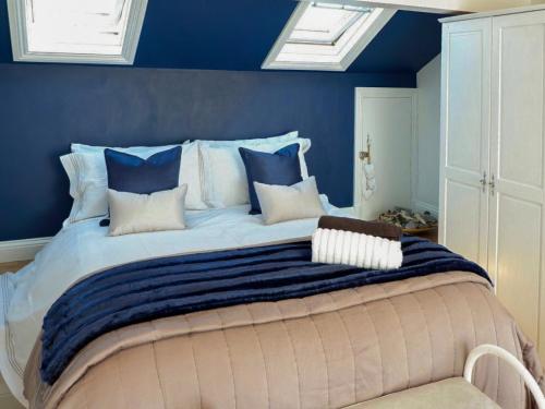 a bedroom with a large bed with blue walls at Wild Duck in Pennington