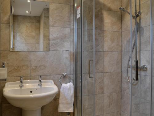 a bathroom with a sink and a shower at Tollgate Cottage in Blythburgh