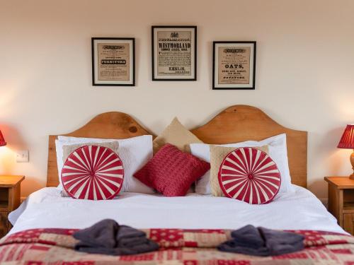 1 dormitorio con 1 cama con almohadas rojas y blancas en Gowan Bank Farm Cottage, en Staveley