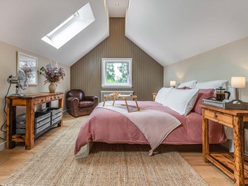 a bedroom with a large bed and a chair at The Granary - Uk34899 in Dunira