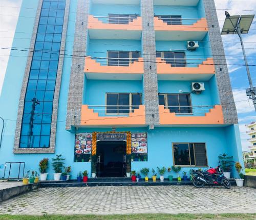 a blue building with a motorcycle parked in front of it at The Lumbini Hotel in Lumbini