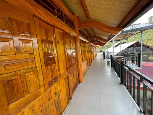a wooden building with wooden doors and a corridor at Homestay Chân Mây Chiêu Lầu Thi in Hoàng Su Phì