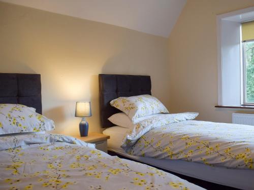 dos camas sentadas una al lado de la otra en un dormitorio en Llantysilio Lodge, en Llangollen