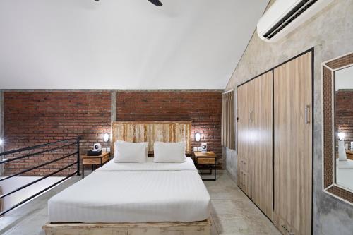 a bedroom with a bed and a brick wall at Ambara U6 Loft by Hombali in Canggu