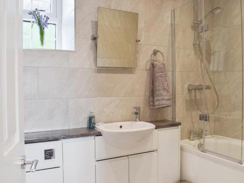 a white bathroom with a sink and a shower at Rooftops - Uk34065 in Grassington