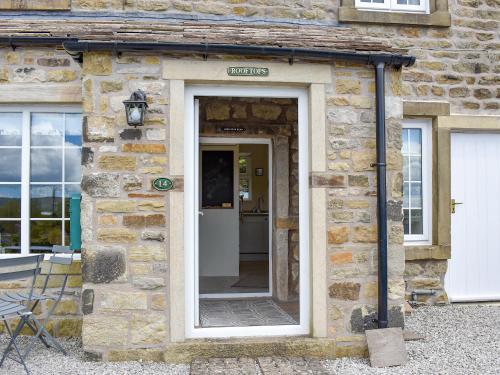a stone building with a door with a sign on it at Rooftops - Uk34065 in Grassington