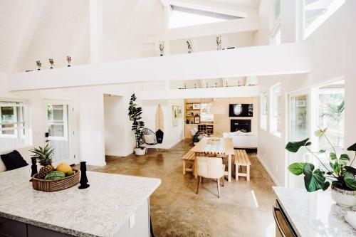 プリンスビルにあるBOHO New Construction: On Golf Course/views/Hot tub AC walk to market and beachの白い壁のリビングルーム(テーブル付)