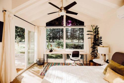 プリンスビルにあるBOHO New Construction: On Golf Course/views/Hot tub AC walk to market and beachのベッドと大きな窓のある寝室