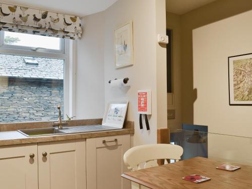 uma cozinha com um lavatório, uma mesa e uma janela em Little Nook em Ambleside