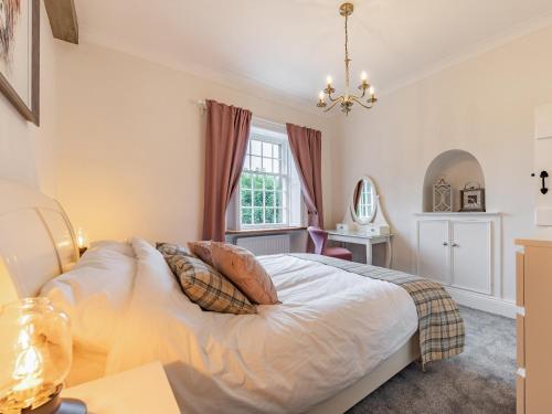 a bedroom with a bed and a window at Catmint Cottage in Highpeak Junction