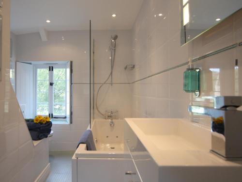 een witte badkamer met een bad en een wastafel bij Tintern Abbey Cottage in Tintern