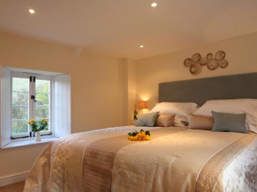 ein Schlafzimmer mit einem großen Bett mit einer Obstschale darauf in der Unterkunft Tintern Abbey Cottage in Tintern