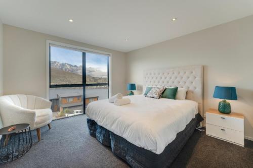 ein Schlafzimmer mit einem Bett, einem Stuhl und einem Fenster in der Unterkunft Queenstown Lake and Mountain View Retreat Free Wifi Free Street Parking in Queenstown