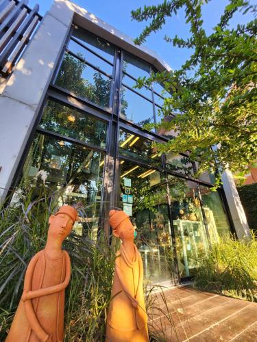 three statues in front of a glass building at Baan Mai Kradan Hostel Chiang Rai in Chiang Rai