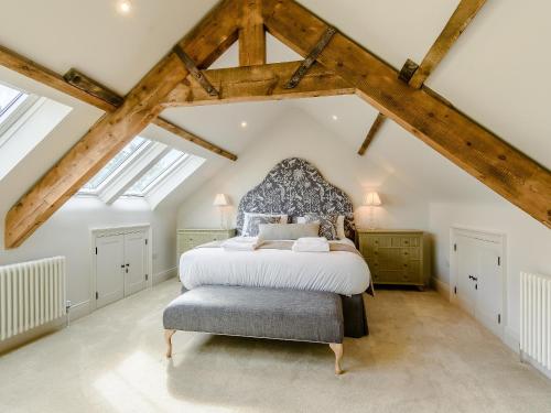 a bedroom with a large white bed and wooden beams at The Old Chapel in Slaley