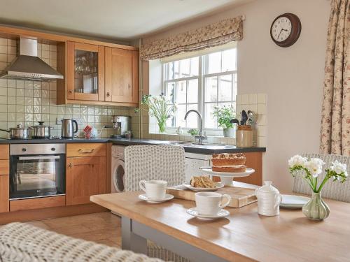 a kitchen with a table with a cake on it at Lockton in Pickering