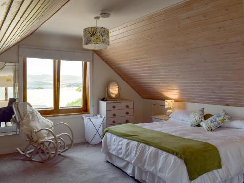 um quarto com uma cama grande e um tecto em madeira em Seal Rocks em Lendalfoot
