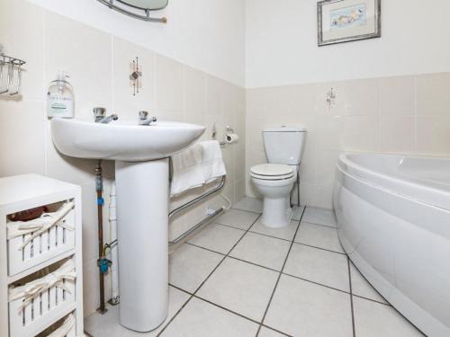 a bathroom with a sink and a toilet and a tub at Taigh Na Beadan in Valtos