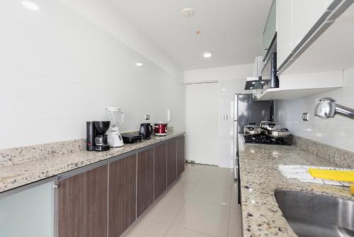 a kitchen with a sink and a counter top at Skyliving Towers Apartments - Perú in Lima