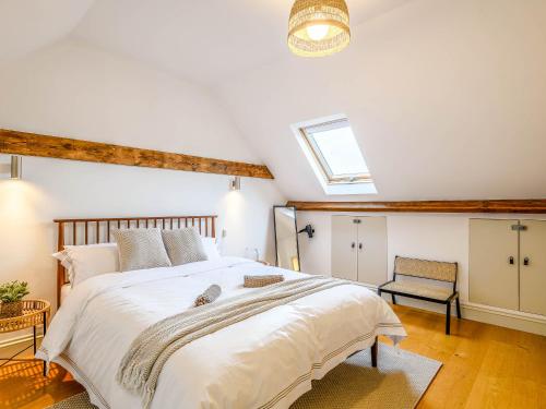 ein Schlafzimmer mit einem großen Bett und einem Dachfenster in der Unterkunft Wisteria Cottage in Heacham