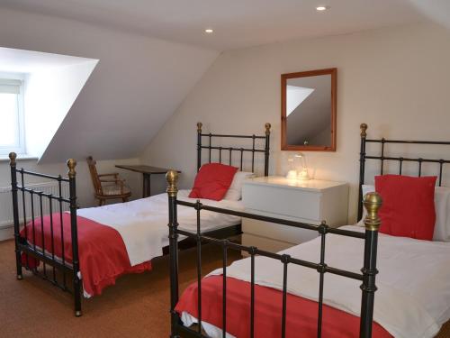 a bedroom with two bunk beds and a mirror at Jicklings in Wells next the Sea